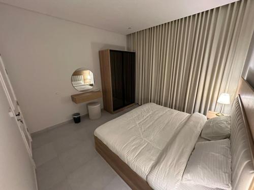 een slaapkamer met een wit bed in een kamer bij Almajdiah Village Luxury Self-entry Al Malqa in Riyad