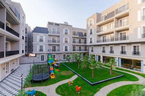 een appartementencomplex met een speeltuin op de binnenplaats bij Almajdiah Village Luxury Self-entry Al Malqa in Riyad