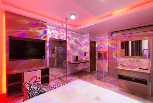 baño púrpura con lavabo y TV en Motel Fashion ABC 2 en Santo André