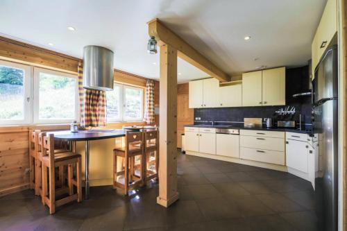 une cuisine avec des armoires blanches et une table et des chaises dans l'établissement Les Chalets de Flaine Hameau - maeva Home - Chalet 7 Pièces 12 Personnes - Prestige MAE-3379, à Flaine
