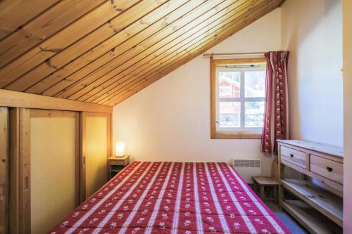 une chambre avec un lit avec une couverture rouge dans l'établissement Les Chalets de Flaine Hameau - maeva Home - Chalet 4 Pièces 8 Personnes - Sélection MAE-3386, à Flaine