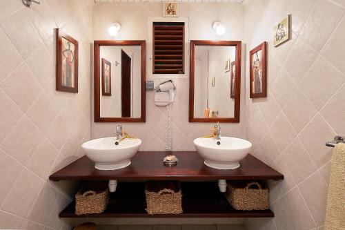 łazienka z 2 umywalkami i lustrami na ścianie w obiekcie Villa Kaz Coco w mieście Deshaies