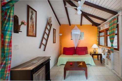 sypialnia z łóżkiem z czerwonymi poduszkami i stołem w obiekcie Villa Kaz Coco w mieście Deshaies