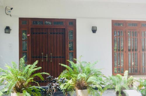 une paire de portes en bois sur un bâtiment avec des plantes dans l'établissement Mango Monkey Retreat, à Galewela