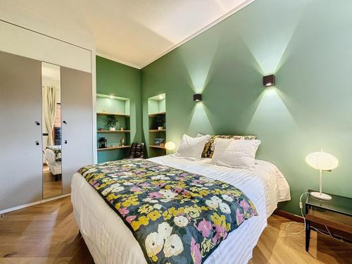 - une chambre avec un grand lit et des murs verts dans l'établissement L'Horizon Aixois, à Aix-les-Bains