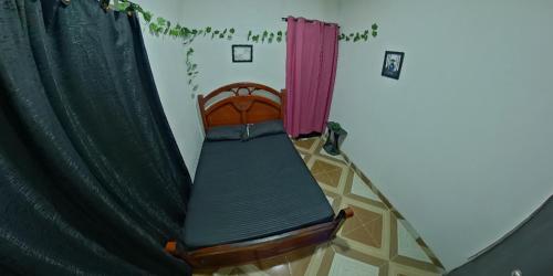 a bed in a room next to a curtain at Akainoie in Minca