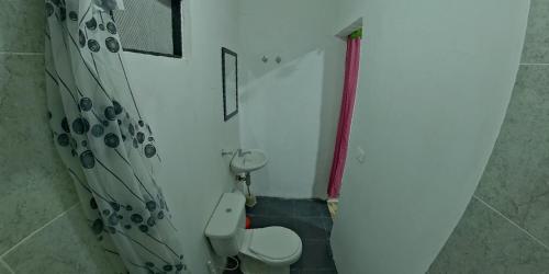 a bathroom with a toilet and a shower curtain at Akainoie in Minca