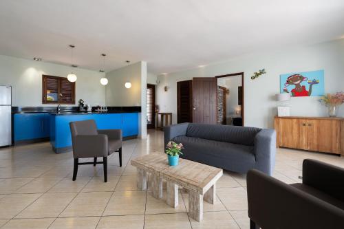 a living room with a couch and a table at Kunuku Resort All Inclusive Curacao, Trademark by Wyndham in Willemstad