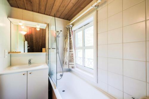 une salle de bain avec une baignoire, un lavabo et une fenêtre dans l'établissement Les Chalets de Flaine Hameau - maeva Home - Chalet 4 Pièces 8 Personnes - Sélection MAE-3391, à Flaine