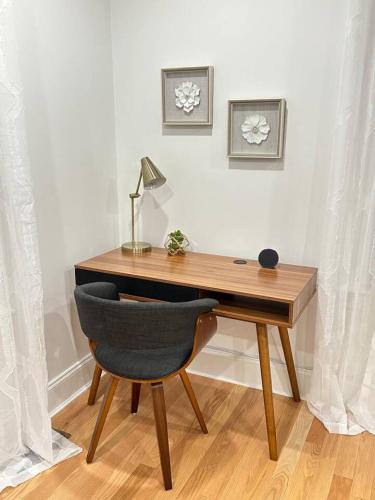 a wooden desk with a chair and a lamp on it at Home Away From Home in Lowell in Lowell