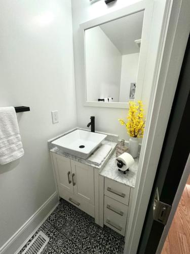 a bathroom with a white sink and a mirror at Home Away From Home in Lowell in Lowell