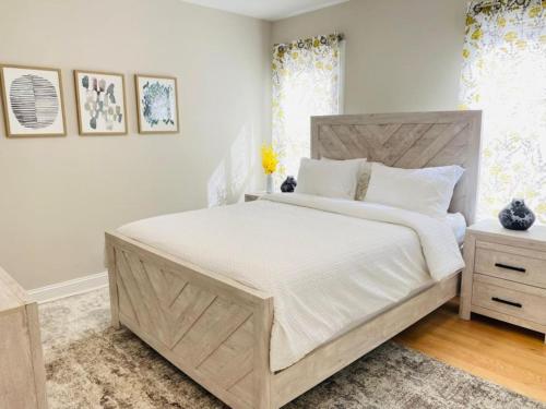 1 dormitorio con 1 cama grande con sábanas blancas en Modern and all new 3BR near UMASS, en Lowell