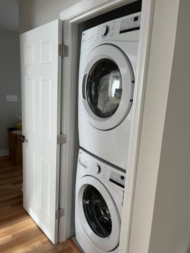 a washing machine and a washer and dryer in a room at Modern, All New 3BR Near UMASS in Lowell