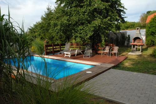 a swimming pool in a yard with a wooden deck at Ubytování Vila Sobotka in Sobotka