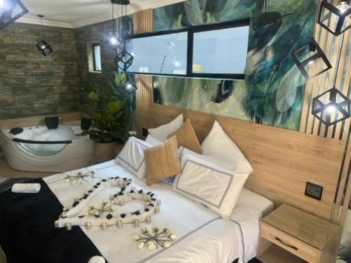 een slaapkamer met een groot bed en een bad bij Africa Paradise - OR Tambo Airport Boutique Hotel in Benoni