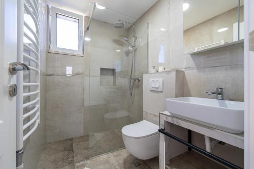 a bathroom with a toilet and a sink and a shower at Ventus Rosa Villa in Budva