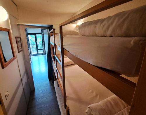 Cette petite chambre comprend 2 lits superposés et un couloir. dans l'établissement Résidence Andromède - maeva Home - Studio 4 Personnes - Confort MAE-3649, à Flaine