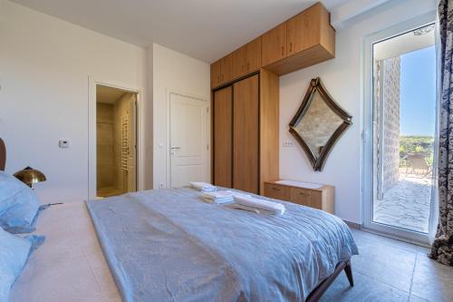a bedroom with a large bed and a mirror at Ventus Rosa Villa in Budva