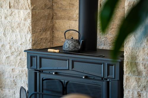 a black stove with a kettle on top of it at Ventus Rosa Villa in Budva