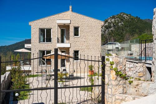 a brick house with a fence in front of it at Ventus Rosa Villa in Budva
