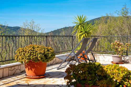 two chairs and potted plants on a balcony at Ventus Rosa Villa in Budva