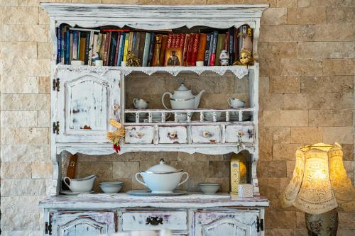 a white cabinet with dishes on top of it at Ventus Rosa Villa in Budva