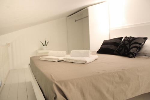 a white room with a bed with towels on it at Uno Spettacolo Della Natura, Modern Style in San Lucido