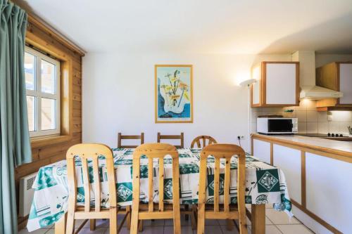 une cuisine et une salle à manger avec une table et des chaises dans l'établissement Les Chalets de Flaine Hameau - maeva Home - Chalet 3 Pièces 8 Personnes - Confort MAE-3654, à Flaine