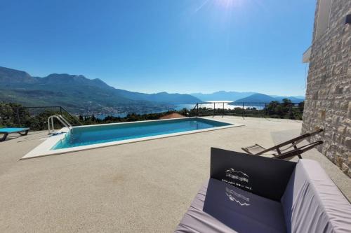 a villa with a swimming pool and mountains in the background at Bay View Village -Villa Eléanora 4 in Herceg-Novi