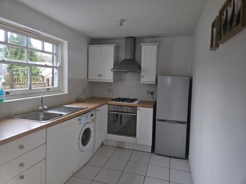 a kitchen with a refrigerator and a stove and a sink at Cwmynyscoy Cottage Pontypool NP4 5SQ in Pontypool