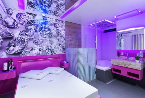 Baño púrpura con cama y lavabo en Motel Fashion ABC 4, en Santo André