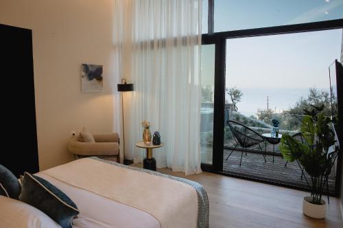 a bedroom with a bed and a large window at Five Olive Dream Trip - Luxury Suites with Sea View in Plomari