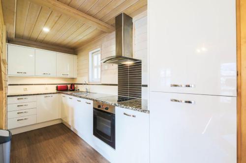 une cuisine avec des armoires blanches et une cuisinière dans l'établissement Les Chalets de Flaine Hameau - maeva Home - Chalet 5 Pièces 8 Personnes - Prestige MAE-3655, à Flaine