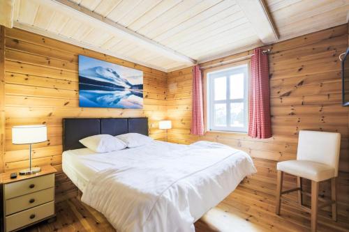une chambre avec un lit, une chaise et une fenêtre dans l'établissement Les Chalets de Flaine Hameau - maeva Home - Chalet 5 Pièces 8 Personnes - Prestige MAE-3655, à Flaine