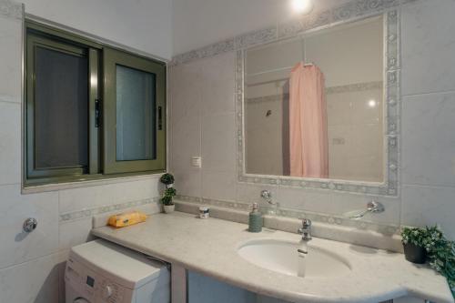 W łazience znajduje się umywalka i lustro. w obiekcie Nefeli City Apartments w mieście Patras