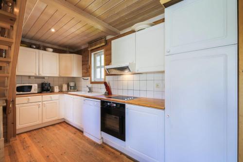 une cuisine avec des armoires blanches et des appareils électroménagers blancs dans l'établissement Les Chalets de Flaine Hameau - maeva Home - Chalet 5 Pièces 8 Personnes - Confort MAE-3661, à Flaine
