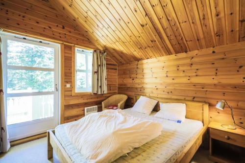 une chambre avec un lit dans une cabane en bois dans l'établissement Les Chalets de Flaine Hameau - maeva Home - Chalet 4 Pièces 8 Personnes - Confort MAE-3660, à Flaine
