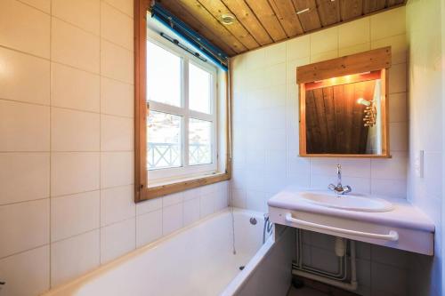 une salle de bain avec un lavabo, une baignoire et un miroir dans l'établissement Les Chalets de Flaine Hameau - maeva Home - Chalet 4 Pièces 8 Personnes - Confort MAE-3660, à Flaine