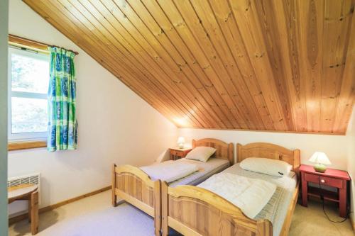 deux lits dans une chambre avec un plafond en bois dans l'établissement Les Chalets de Flaine Hameau - maeva Home - Chalet 4 Pièces 8 Personnes - Confort MAE-3662, à Flaine