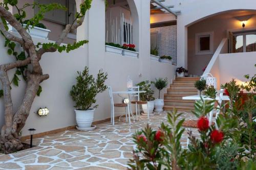 a courtyard with a table and chairs and potted plants at Boutique Mare in Galissas