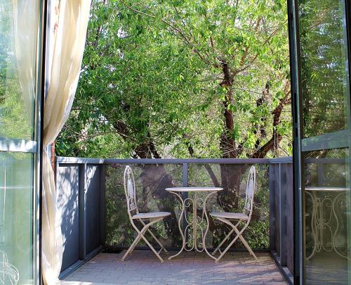 a balcony with two chairs and a table and trees at Appartamento Levante in Bologna