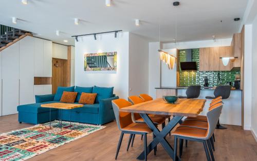 sala de estar con sofá azul y mesa de madera en New Gudauri Apartments, en Gudauri