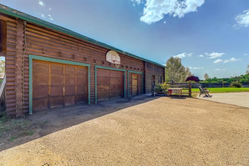 a building with two garage doors and a basketball hoop at Spacious Pinedale Home with Mountain Range View in Pinedale