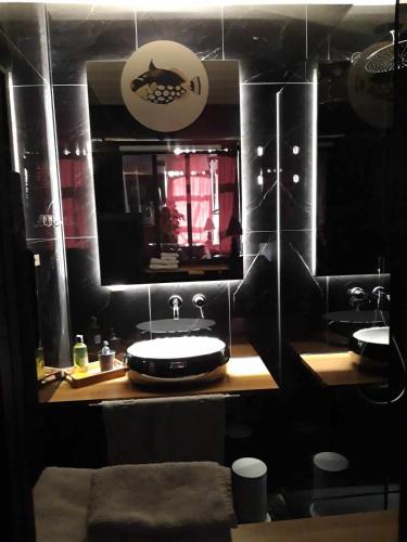 Baño negro con lavabo y espejo en Chimay Welcome en Chimay