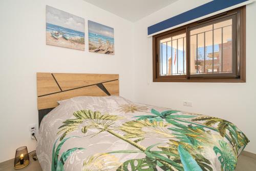 a bedroom with a bed with a tropical print on it at Tortuga Marina in San Juan de los Terreros