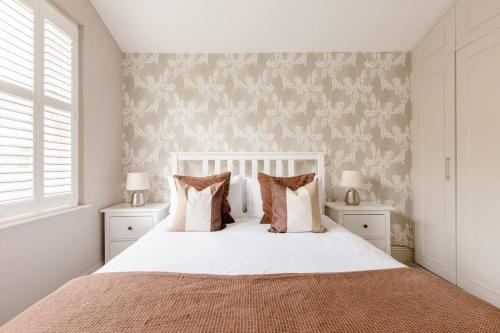 1 dormitorio con 1 cama blanca y 2 mesitas de noche en Luxury King-bed Ensuite With Tranquil Garden Views, en Londres