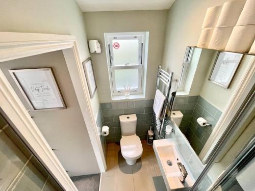 La petite salle de bains est pourvue de toilettes et d'un miroir. dans l'établissement Luxury King-bed Ensuite With Tranquil Garden Views, à Londres