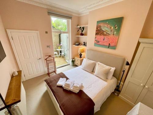 ein Schlafzimmer mit einem großen Bett mit weißer Bettwäsche in der Unterkunft Luxury King-bed Ensuite With Quiet Private Patio in London
