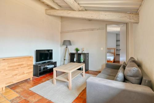 uma sala de estar com um sofá e uma mesa em Prêcheurs furnished flat em Aix-en-Provence