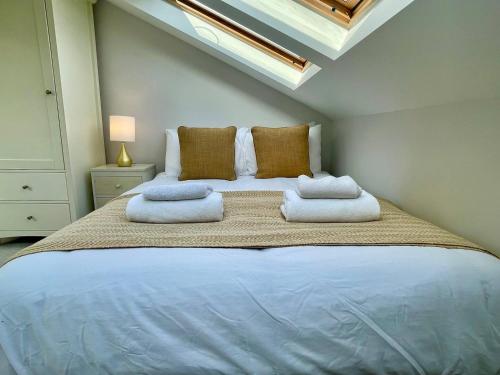 um quarto com uma cama grande e toalhas em Bright Quiet Loft Room Ensuite Serene Clapham Area em Londres